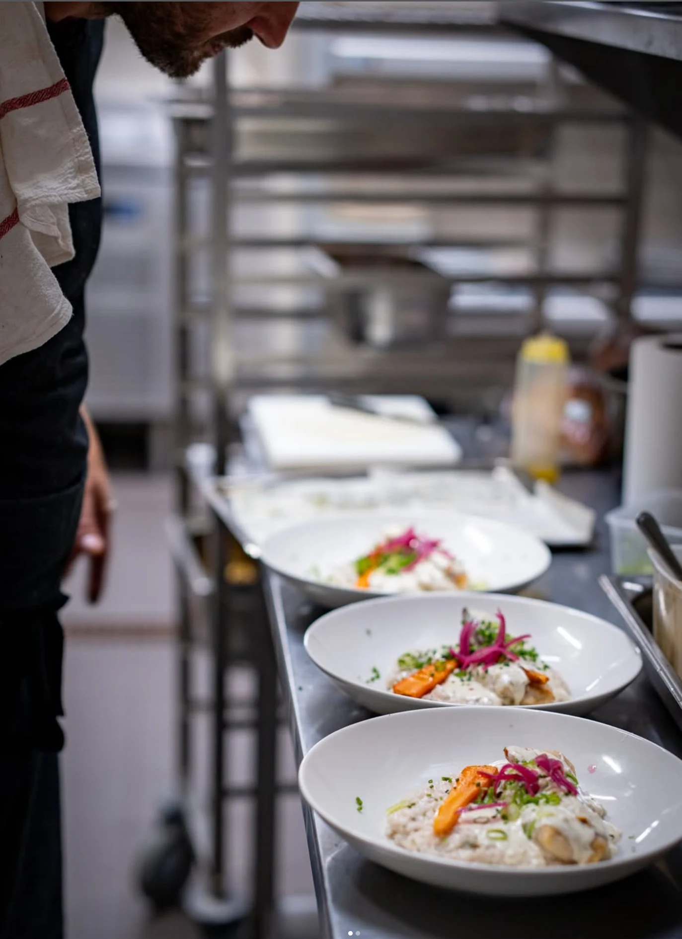 Cuisinier qui dresse ses assiettes dans son restaurant